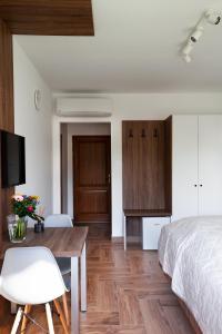 1 dormitorio con cama, escritorio y mesa en HVT Comfort Apartments en Mezőkövesd