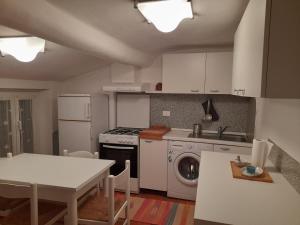 a kitchen with a stove and a sink and a washing machine at La soffitta vicino al mare in Varazze
