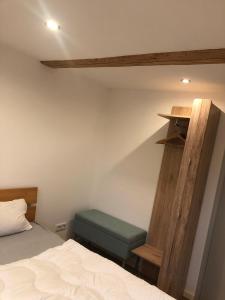 a small bedroom with a bed and a wooden shelf at Bike & Sleep Weserbergland Ferienhaus in Vahlbruch