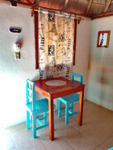 uma mesa e duas cadeiras e uma mesa e uma mesa e cadeiras em Veleando Ando Cabañas em Bacalar