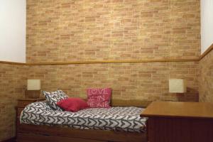 a bed with two pillows and a brick wall at CASA ALIS in Arrecife