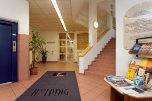 - un hall d'un bâtiment avec un panneau apposé sur un tapis dans l'établissement Kolpinghaus Innsbruck, à Innsbruck