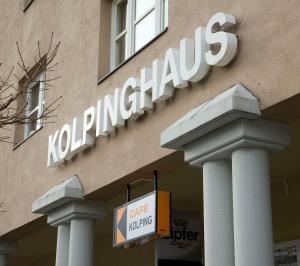 a sign on the side of a building with columns at Kolpinghaus Innsbruck in Innsbruck