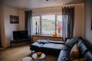 a living room with a couch and a large window at Waldblick Herborn in Herborn