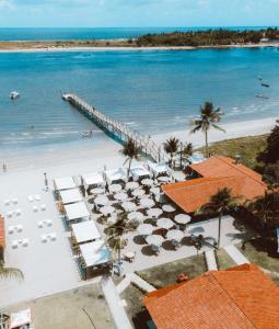 a view of a beach with umbrellas and a pier at Catamaran Praia Chalés in Igarassu