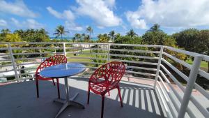 2 sillas rojas y una mesa en el balcón en Strand Ocean Drive Suites, en Miami Beach