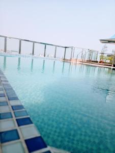 a swimming pool with blue water and a fence at The Castle Inn in Dhaka