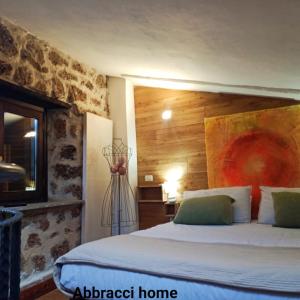 1 dormitorio con 1 cama grande y cabecero de madera en Abbracci Home Barbarano, en Barbarano Romano