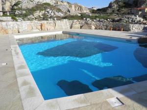 una grande piscina con acqua blu di Villa La Forgia a La Maddalena