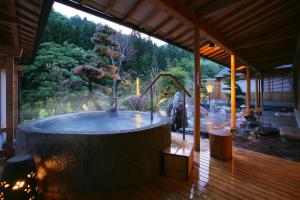 a large hot tub on a wooden deck at 游泉志だて in Hanamaki