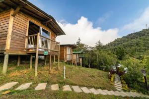 una cabaña de madera en una colina con una casa en Cerro Verde Mirador, en Medellín