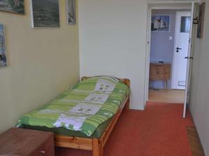 a small bedroom with a bed with a green blanket at Apartament z Widokiem in Gdynia