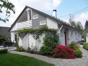 a white house with a fence and flowers at Ferienwohnungen Gabi Karnowski in Gernsbach