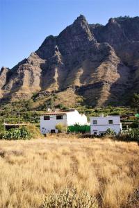 uma casa num campo com uma montanha ao fundo em La Casa del Orobal em Agaete