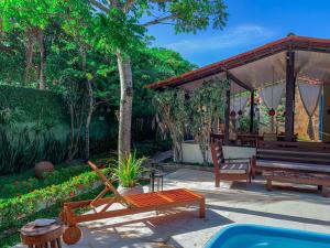 a patio with a bench and a picnic table at Pousada Carioca - Pousada de Charme in Jericoacoara