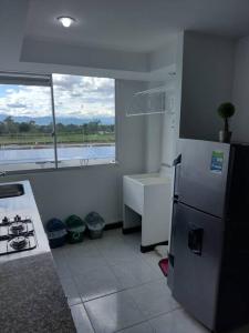 cocina con nevera, fregadero y ventana en Apartamento a 3Km del Parque del Cafe, en Montenegro