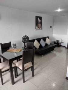 sala de estar con mesa y sofá negro en Apartamento a 3Km del Parque del Cafe, en Montenegro