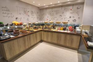 uma linha de buffet com muitos tipos diferentes de alimentos em Pousada Bella Viena em Gramado