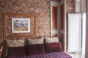 a bedroom with a stone wall and a bed with pillows at Legendary Bay Apartamento Temático in Seixal