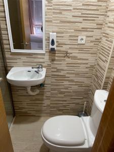 une salle de bain avec des toilettes blanches et un lavabo dans l'établissement Pensión Portugal, à Alicante