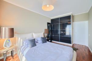 ein Schlafzimmer mit einem Bett und einem großen Fenster in der Unterkunft Charming Deluxe Apartment in Oeiras