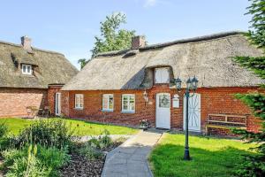 an old brick house with a thatched roof at Semi-detached house Posthus, Behrendorf in Behrendorf