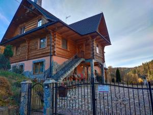 a large wooden house with a fence in front of it at Luksusowa Willa w sercu Gorców in Ochotnica Górna