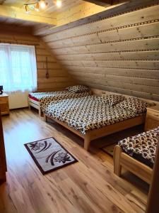 a room with two beds in a log cabin at Luksusowa Willa w sercu Gorców in Ochotnica Górna