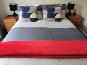 - un grand lit avec une couverture rouge dans l'établissement ASURE Ascot Motor Inn, à Taupo