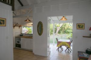 a kitchen and dining room with a table and a table and a table at Gite le colibri Bungalow Azur avec réserve d'eau in Saint-François