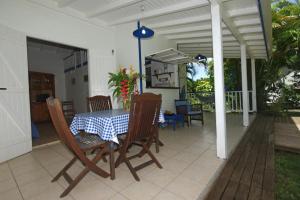 a table with a blue and white table cloth on a porch at Gite le colibri Bungalow Azur avec réserve d'eau in Saint-François