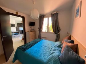 1 dormitorio con 1 cama con edredón azul en Appartement Dolce Farniente, en Belgodère