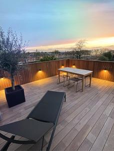 a patio with a table and benches on a deck at Casa Clementina - Luxury Penthouse with Airconditioning and Private Terrace in Ghent