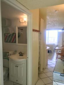 a bathroom with a sink and a mirror and a room at Ocean Waves - Ocean Front at Symphony Beach Club! in Ormond Beach