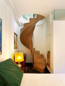 Una escalera de caracol en un dormitorio con una cama. en Depadance Limoni, en Gardone Riviera