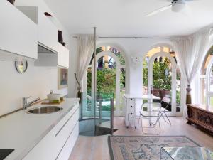 a kitchen with white counters and a table and chairs at Depadance Limoni in Gardone Riviera