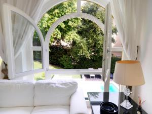 a living room with a white couch and a large window at Depadance Limoni in Gardone Riviera
