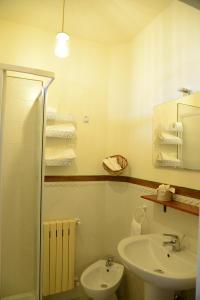 een badkamer met een wastafel, een toilet en een spiegel bij La Casa Di Andrea in Chieti