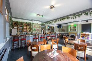 a restaurant with tables and chairs and a bar at The Shurland Hotel Gym Spa in Eastchurch