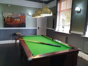 a pool table in a room with a green cloth at The Shurland Hotel Gym Spa in Eastchurch