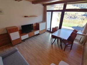 een woonkamer met een tafel en een televisie bij Hintermoos in Bachwinkl