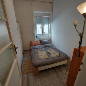 ein kleines Schlafzimmer mit einem Bett und einem Fenster in der Unterkunft Relax inn Condominium-Zagreb in Zagreb