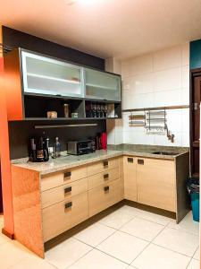 - une cuisine avec un comptoir et un four micro-ondes dans l'établissement Flat Portal de Gravatá Hotel Fazenda - Flat 4 suítes, à Gravatá