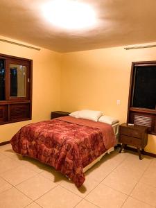 - une chambre avec un lit et une couverture rouge dans l'établissement Flat Portal de Gravatá Hotel Fazenda - Flat 4 suítes, à Gravatá
