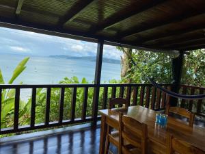 stół i krzesła na balkonie z widokiem na ocean w obiekcie Cabaña Ara Macao Lodge w mieście Bahía Drake