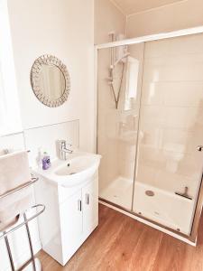 a white bathroom with a shower and a sink at Amy’s Annex in Bransgore