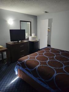 a hotel room with a bed and a flat screen tv at Super 8 North Red Deer in Red Deer