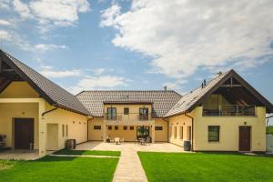 an exterior view of a house with a yard at Dominium Pincészet és Panzió in Gyöngyös