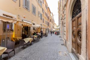 una calle vacía con mesas, sillas y edificios en VG PIAZZA DEL POPOLO 5 STELLE Appartamento Elegante en Roma