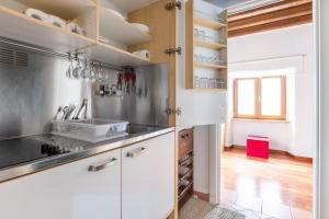 una cocina con armarios blancos y electrodomésticos de acero inoxidable en VG PIAZZA DEL POPOLO 5 STELLE Appartamento Elegante en Roma